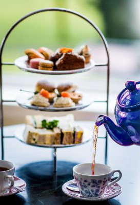 biscuits, sandwiches and tea being poured